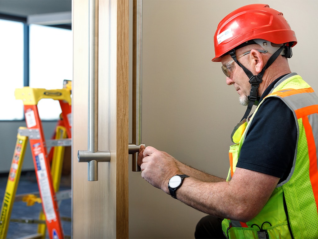 WORRKS employee in safety gear installing door handle