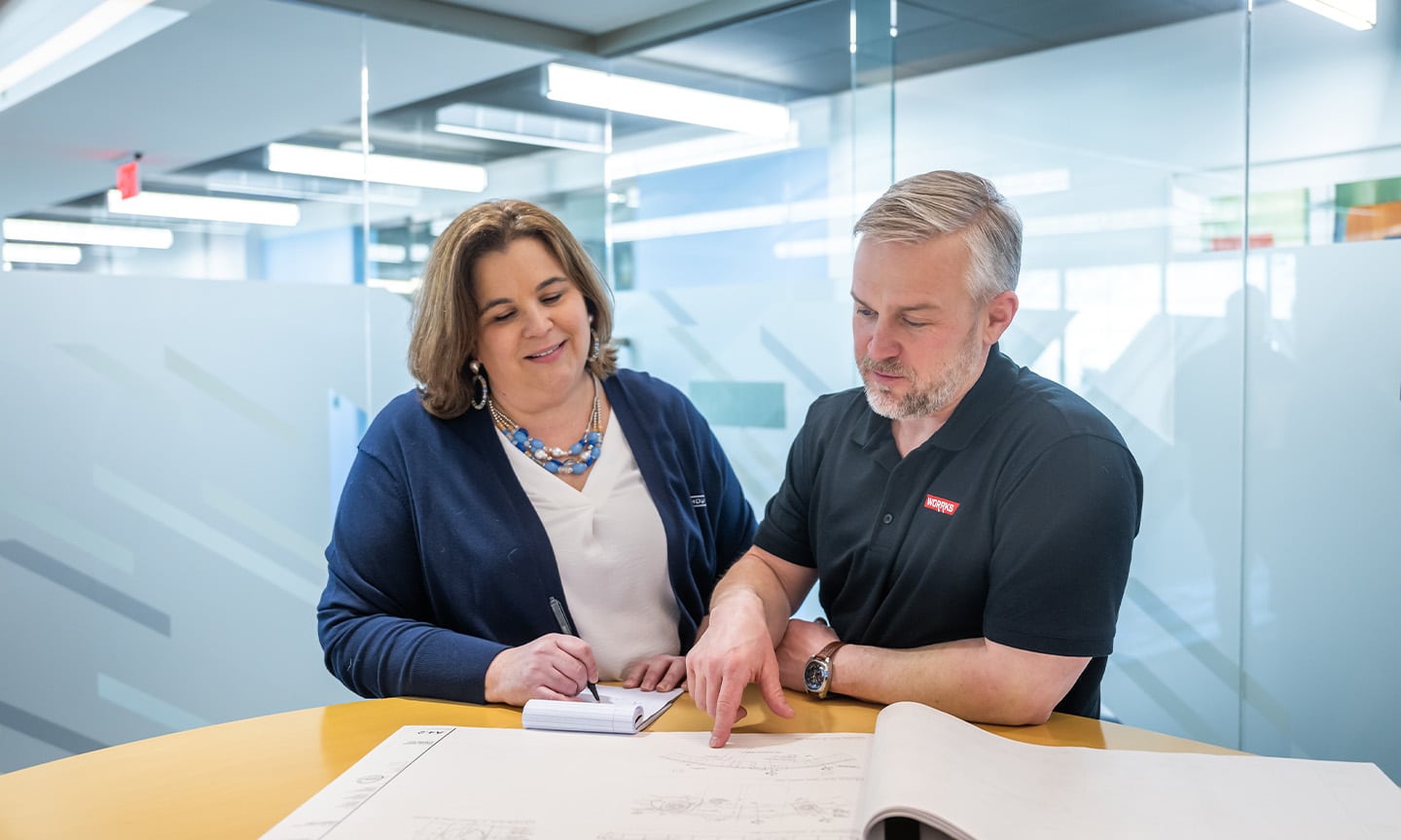 Two people looking at diagrams on a paper